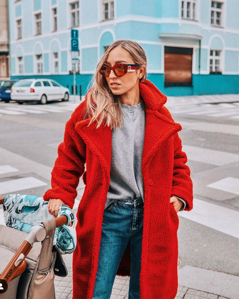 fashionable woman with a stroller wearing sunglasses and a prague red oversized faux fur teddy coat
